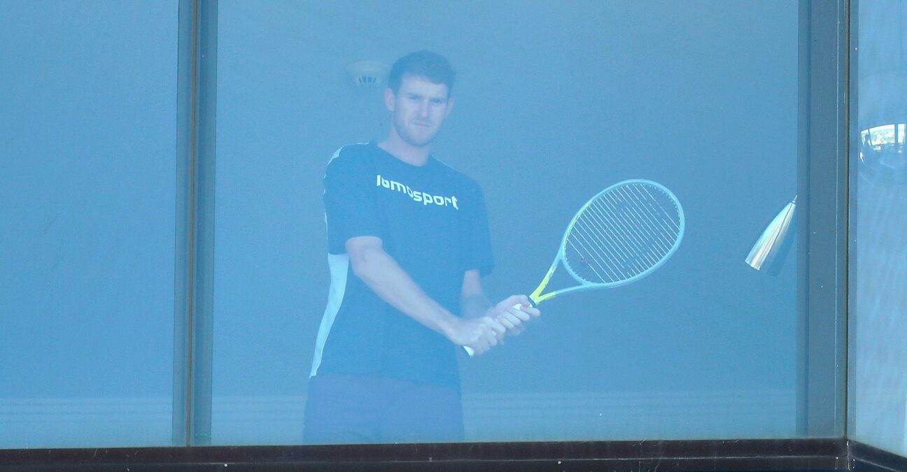 A tennis player practices with a racket inside a room at a hotel where players are undergoing mandatory quarantine in advance of the Australian Open in Melbourne, Australia, January 21, 2021